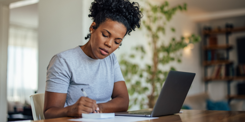 woman writing on a notepad